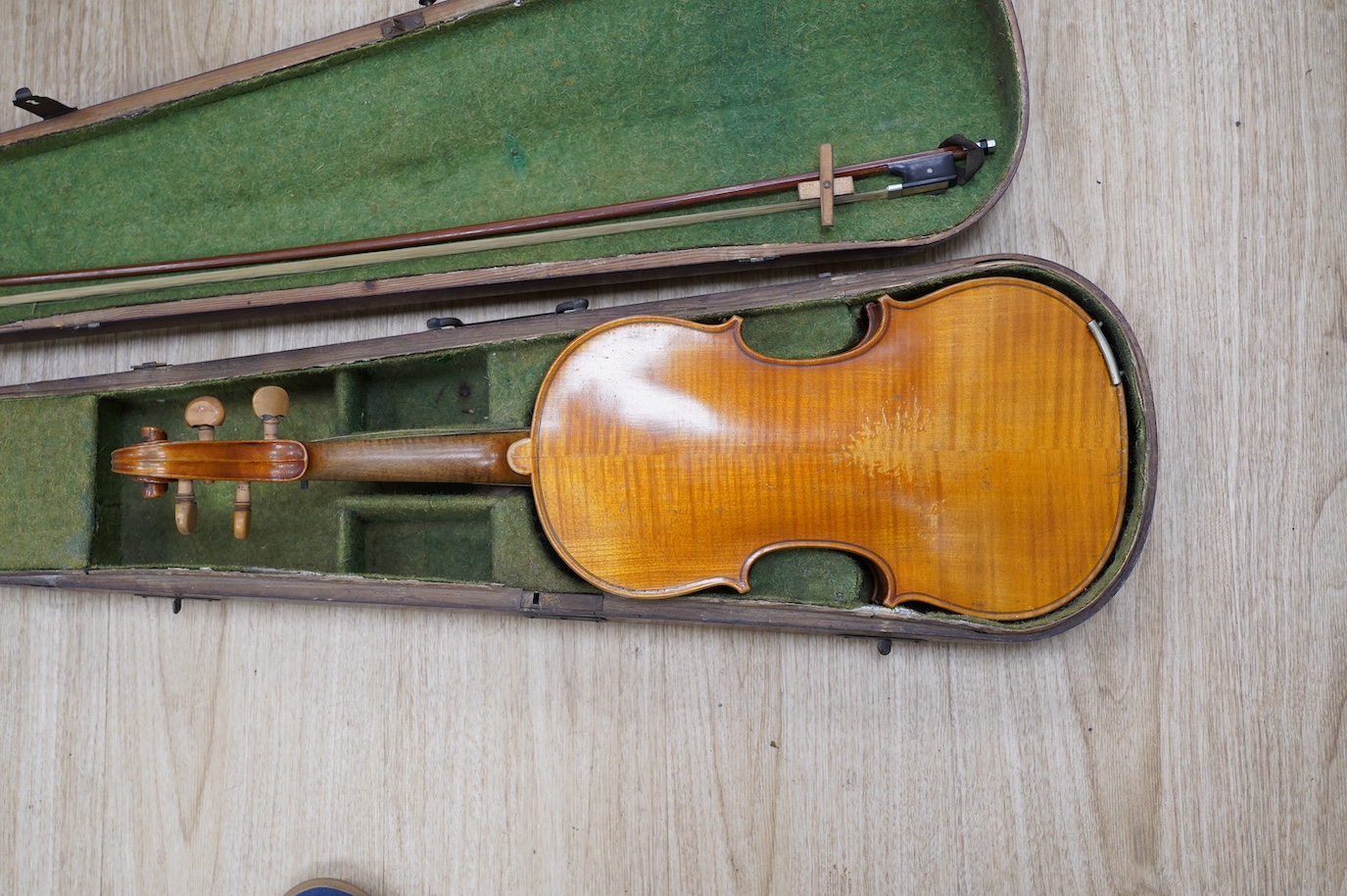 A late 19th century German violin, bearing a Stradivarius label, dated 1717, with mother of pearl inlaid tailpiece, in a walnut case and with bow, the bow stamped Vuillaume & Paris. Condition - fair